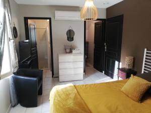 1 dormitorio con cama amarilla y espejo en Bellevue Les Carlines, en Marcillac-Vallon