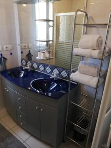 y baño con lavabo azul y espejo. en Bellevue Les Carlines, en Marcillac-Vallon