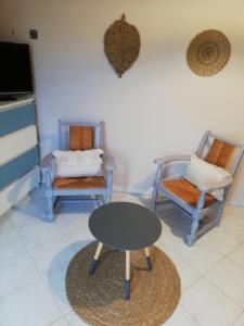 sala de estar con 2 sillas y mesa en Bellevue Les Carlines, en Marcillac-Vallon
