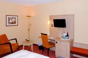 ein Hotelzimmer mit einem Bett und einem Schreibtisch mit einem TV in der Unterkunft Hotel St.Martiner Castell in Sankt Martin