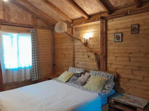 a bedroom with a bed in a log cabin at Tiny houses Genacvale in Martvili