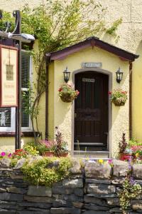 een gebouw met een deur en bloemen ervoor bij The Cottage in Windermere