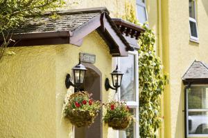 un edificio con due cesti di fiori e due luci di The Cottage a Windermere