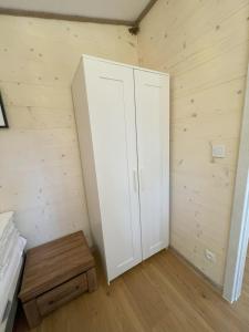1 dormitorio con armario blanco y suelo de madera en Ośrodek Polaris en Dziwnówek