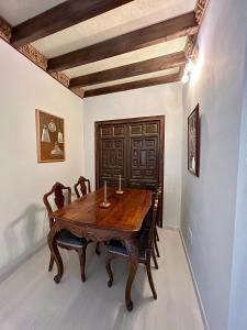ein Esszimmer mit einem Holztisch und Stühlen in der Unterkunft Apartamento La Medina in Guadix