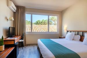 a hotel room with a bed and a desk and a window at Hotel Hostalillo by Escampa Hotels in Tamariu