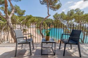 two chairs and a table on a balcony with a view of the water at Hotel Hostalillo by Escampa Hotels in Tamariu