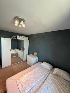 1 dormitorio con cama y pared negra en Koselig leilighet på Bystranden en Kristiansand