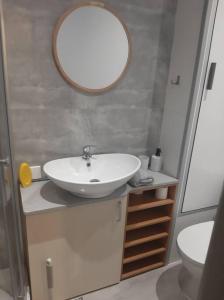 łazienka z umywalką i lustrem na ścianie w obiekcie Apartament Komfortowy - w pełni wyposażony - SpaceApart w Jeleniej Górze