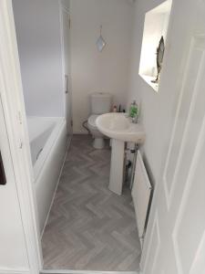 a white bathroom with a sink and a toilet at Flat sleeps 5 people in Guisborough in Guisborough