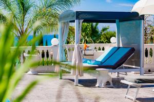 a blue swing on a beach with palm trees at Villa La Perla in Licata