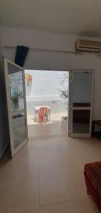 Chouette villa au bord de la plage hergla في سوسة: غرفة مع باب مفتوح مطلة على الشاطئ
