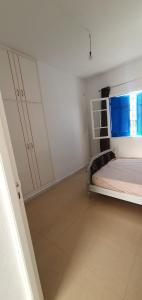 ein weißes Zimmer mit einem Bett und einem Fenster in der Unterkunft Chouette villa au bord de la plage hergla in Sousse