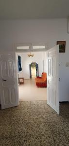 ein Zimmer mit einer offenen Tür und einer roten Couch in der Unterkunft Chouette villa au bord de la plage hergla in Sousse