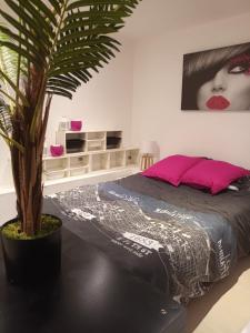 sypialnia z łóżkiem i palmą w obiekcie Location venelles w mieście Venelles