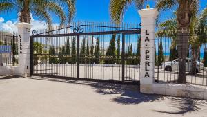 a gate with a sign that reads la entrada at Villa La Perla in Licata