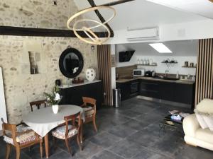 Loft à Tours Nord في تور: مطبخ وغرفة معيشة مع طاولة وكراسي