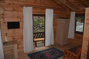 ein Wohnzimmer mit einem Fenster in einem Blockhaus in der Unterkunft DERE AĞZI TATİL KÖYÜ in Rize