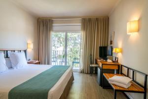 a hotel room with a bed and a balcony at Hotel Hostalillo by Escampa Hotels in Tamariu
