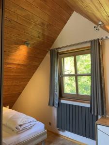 a bedroom with a bed and a window in a room at Ferienhaus 39 Kratzmühle Altmühlthal in Kinding