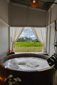 bañera grande en una habitación con ventana en Baanfanglamoon 