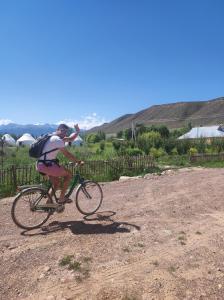 a person riding a bike on a dirt road at Eco Village Lodge in Dzhetyoguz