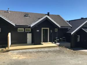 una casa nera con portico e porta di Voss - Flott hytte i Bavallen a Skulestadmo