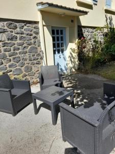 a group of chairs and tables in front of a building at La maison de Denise et Henri in Le Vigean