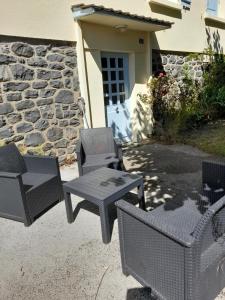 a group of chairs and tables in front of a building at La maison aux volets bleus in Le Vigean