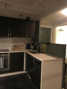 a kitchen with black and white cabinets and a sink at Voss - Flott hytte i Bavallen in Skulestadmo