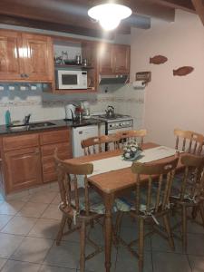 a kitchen with a wooden table with chairs and a stove at Cabañas LUGAR SOÑADO in San Martín de los Andes