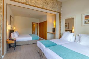 a hotel room with two beds and a table at Hotel Hostalillo by Escampa Hotels in Tamariu