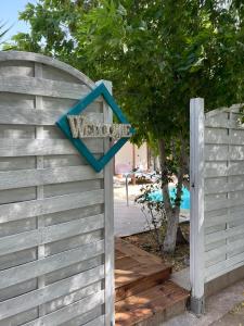 a wooden fence with a blue arrow sign on it at Villa Adonis with private pool by Lefkadastay in Lefkada Town