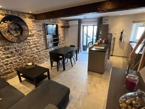 a kitchen and living room with a stone wall at Gîte de charme avec terrasse in Fleurie