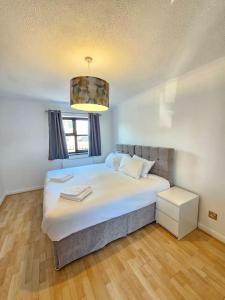 a bedroom with a large white bed with a chandelier at Amazing 6BR, Sleeps 10, Large Garden, Free Parking 