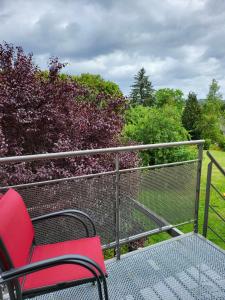 une chaise rouge assise sur une balustrade sur un balcon dans l'établissement A la salle de jeux, à Dinant