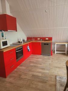 uma cozinha com armários vermelhos e um tecto branco em A la salle de jeux em Dinant