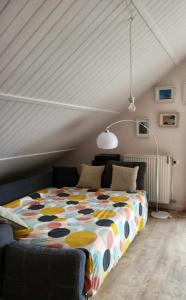 a bedroom with a large bed in a attic at A la salle de jeux et son jardin autour de la cabane verte in Dinant