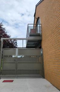 - un bâtiment avec une porte métallique et un balcon dans l'établissement A la salle de jeux, à Dinant