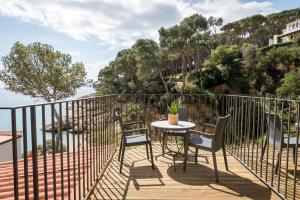 a table and chairs on a balcony with a view of the water at Hotel Hostalillo by Escampa Hotels in Tamariu