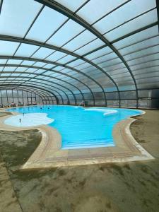 a large swimming pool in a large building at Cottage "SANS SOUCI" chaleureux à 150m de la plage in Jullouville-les-Pins