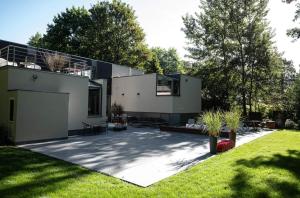 ein großes weißes Haus mit einer Terrasse im Hof in der Unterkunft Table et chambre particulière in Mons