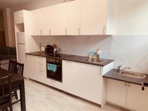 una cocina con armarios blancos y fregadero en LAGA&LAIDA APARTAMENTOS GERNIHOST en Urdaibai, en Guernica y Luno