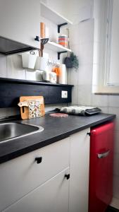 uma cozinha com um lavatório e um armário vermelho em B&B “il Pellicano” em Policoro
