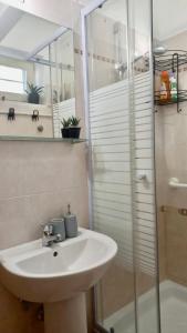 y baño con lavabo y ducha acristalada. en B&B “il Pellicano”, en Policoro