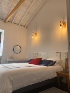 a bedroom with a large white bed with two pillows at PicoComigo in Lajes do Pico