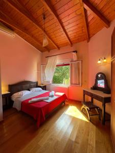 a bedroom with a red bed and a window at Villa Adonis with private pool by Lefkadastay in Lefkada