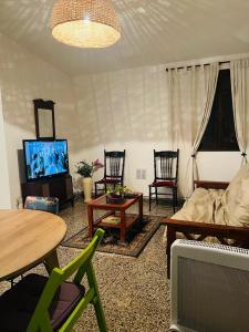 sala de estar con sofá, TV y sillas en ARMONIA en Salta