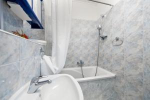 a bathroom with a shower and a sink and a tub at Rovinj Romance Apartment in Rovinj +14 photos
