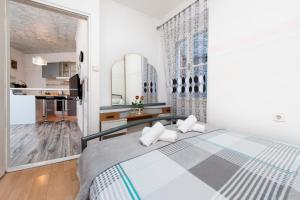 a white bedroom with a bed and a kitchen at Rovinj Romance Apartment in Rovinj